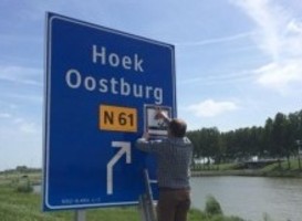 Regiomanager, Arthur van Disseldorp plakt pictogram op bewegwijzeringsbord afslag Oostburg Regiomanager, Arthur van Disseldorp plakt pictogram op bewegwijzeringsbord afslag Oostburg