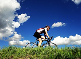 Normal_wielrenner__wielrennen__fietser__gras__blauwe_lucht__wolkjes__bidon__helm